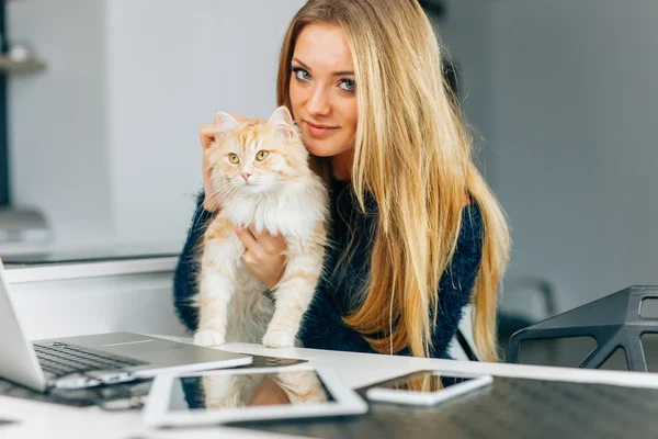 Vacker ung flicka holging hennes ingefära katt. Enheter på kitc — Stockfoto