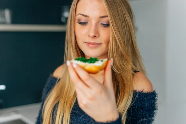 Menina comendo sanduíches na cozinha. Fechar . — Fotografia de Stock