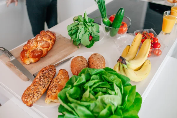 Tafel in de keuken met groenten, fruit en brood op het. — Stockfoto