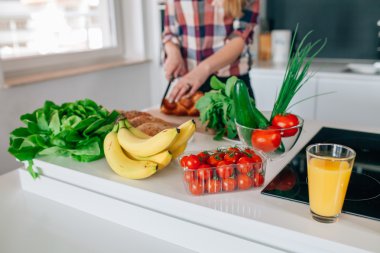 Genç kadın mutfakta yemek hazırlanıyor. Taktırmış bir kız