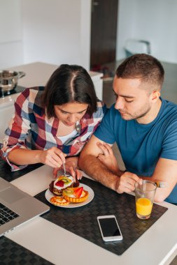 Mutfakta oturmuş ve capcakes fr ile tatma genç Çift