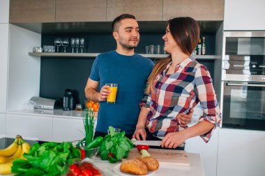 Genç çift akşam yemeği hazırlıyor. Kız kesme besindir. H adamdır