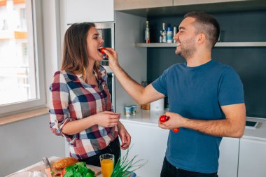 Genç çift mutfakta yiyecek hazırlama. Onun kız adam yayınları
