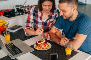 Mutfakta oturmuş ve capcakes fr ile tatma genç Çift