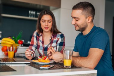 Mutfakta oturmuş ve capcakes fr ile tatma genç Çift