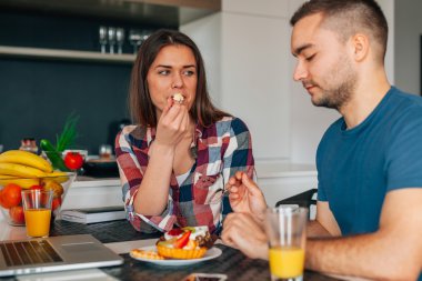 Mutfakta oturmuş ve capcakes fr ile tatma genç Çift