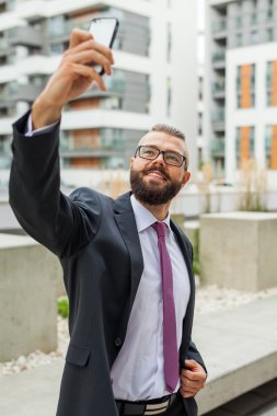 Mutlu genç işadamı dış ofis binası duran sakallı