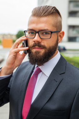 Cep telefonu kullaranarak gözlük takıyor işadamı genç sakallı 