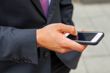 Cep telefonu kullaranarak iş adamı. Yakın çekim.