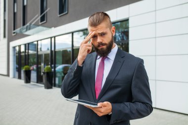 İş yerinde sorunlar nedeniyle baş ağrısı olan genç işadamı.