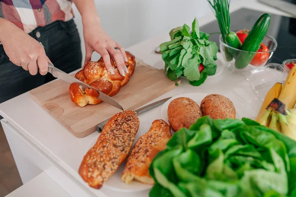 Jonge vrouw bereidt wat te eten in de keuken. Ze is cutti — Stockfoto