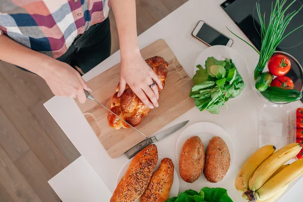 Jonge vrouw bereidt wat te eten in de keuken. Ze is cutti — Stockfoto