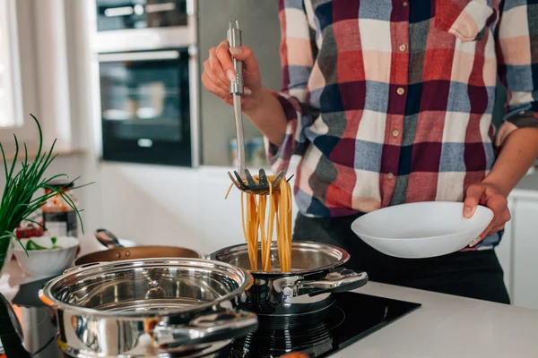 La chica está preparando espaguetis boloñeses. Ella está sacando pasta o — Foto de Stock