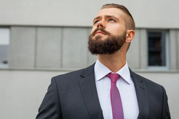 Retrato de un joven empresario enfocado fuera del edificio de oficinas — Foto de Stock