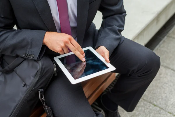 Homme d'affaires assis sur un banc et utilisant tablette pc. Gros plan . — Photo