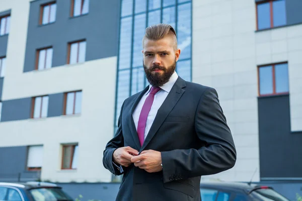 Young attractive businessman ajusting jacket. Outdoor photo. — Stock Photo, Image