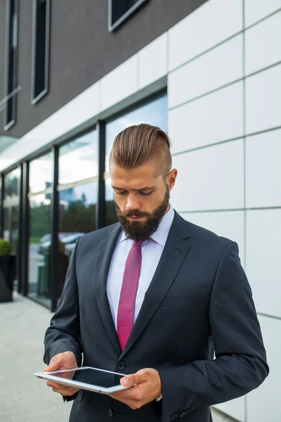 Joven hombre de negocios barbudo escribiendo e-mail de negocios usando su ficha —  Fotos de Stock