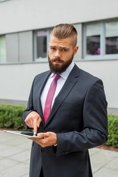 Joven hombre de negocios barbudo escribiendo e-mail de negocios usando su ficha —  Fotos de Stock