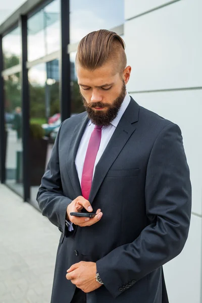 Unga skäggiga affärsman skriva business e-post med sin mob — Stockfoto