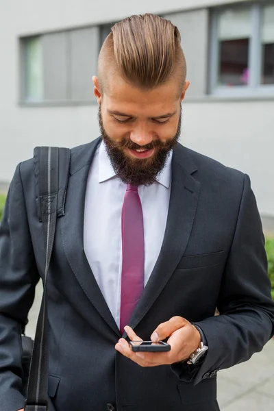 Jong gebaard zakenman schrijven van zakelijke e-mail met behulp van zijn mob — Stockfoto