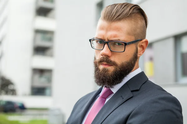 Portrait of a young focused bearded businessman outside the offi — Stock Photo, Image