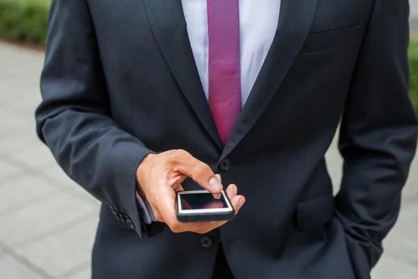 Zakenman met behulp van de mobiele telefoon. Close-up. — Stockfoto