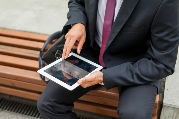 Uomo d'affari seduto su una panchina e utilizzando tablet pc. Da vicino. . — Foto Stock