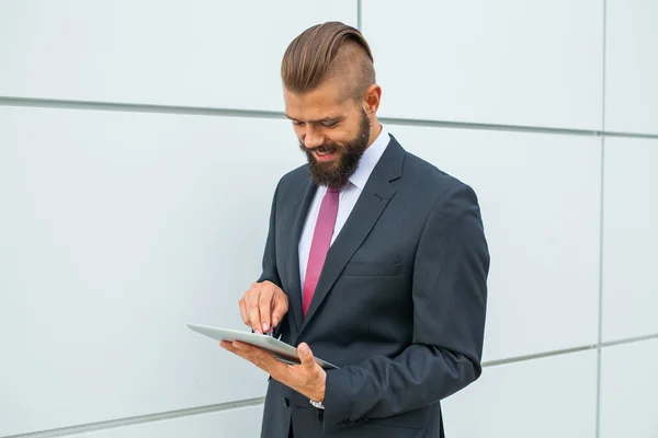 Joven hombre de negocios barbudo escribiendo e-mail de negocios usando su ficha —  Fotos de Stock