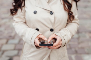 Cep telefonu kullanan kız. Kentsel arka plan. Yakın çekim. 