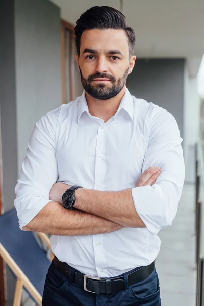 Portrait of a young businessman in a white shirt with arms cross