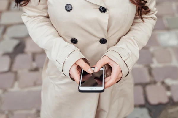 Fille utilisant un téléphone portable. Fond urbain. Gros plan . — Photo