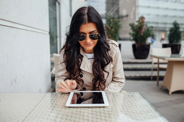 Junges Mädchen mit Tablet-PC, während sie außerhalb des Cafés sitzt. städtisch — Stockfoto