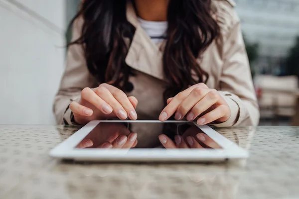 Молодая девушка использует планшетный компьютер, сидя возле кафе. Городские — стоковое фото