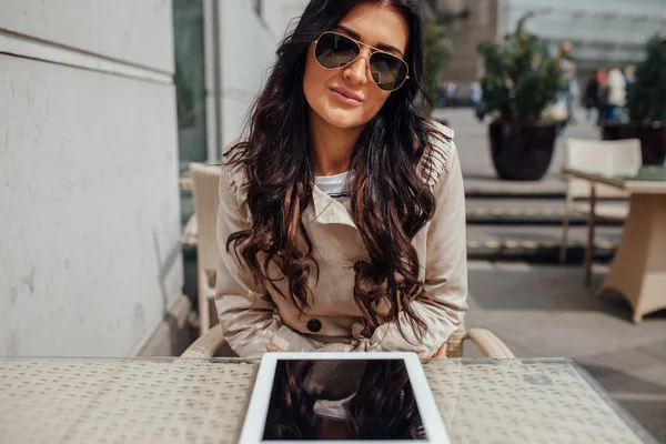 Chica joven usando tableta PC mientras está sentado fuera de la cafetería. Urbano — Foto de Stock