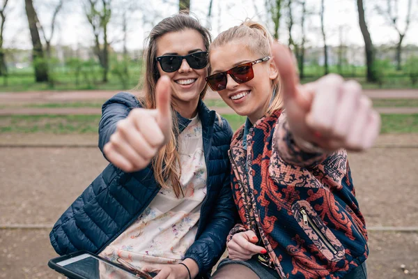 To jenter som sitter på bechen i parken. Positive følelser . – stockfoto