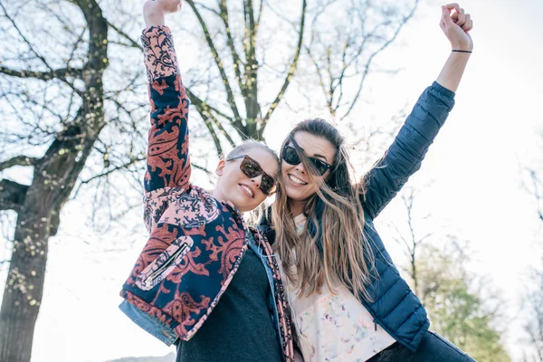 Zwei Mädchen hören Musik im Park. Hände hoch. — Stockfoto