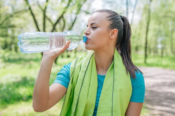 Meisje drinkwater na treaning in het park. — Stockfoto