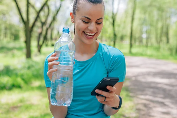 Mädchen trinkt Wasser nach Behandlung und Handy-Nutzung — Stockfoto