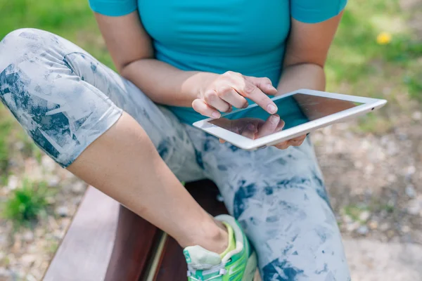 Mädchen benutzt Tablet-PC. Sie hat eine Trainingspause. Nahaufnahme. — Stockfoto