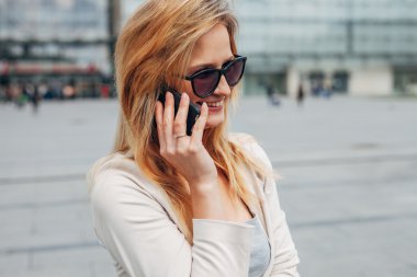 Telefonda konuşurken kız. Kentsel arka plan.