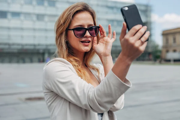 Dziewczyna biorąc selfie. Tła miejskiego. — Zdjęcie stockowe