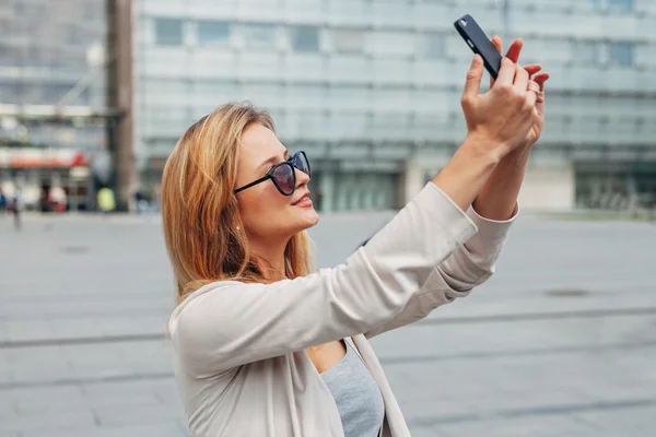 Rapariga a tirar selfie. Fundo urbano . — Fotografia de Stock