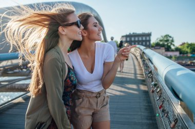 İki kız bir şey işaret. Şehir ve nehir içinde belgili tanımlık geçmiş.