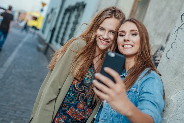 在大街上的两个年轻女孩以自拍照. — 图库照片