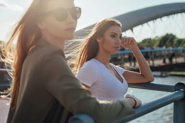 Dvě holky něco ukázal. Město a řeka v pozadí. — Stock fotografie