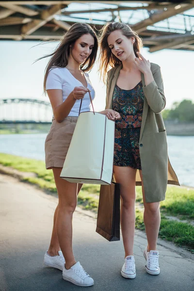 Zwei Mädchen, die nach dem Einkaufen gehen und darüber reden, was sie essen — Stockfoto
