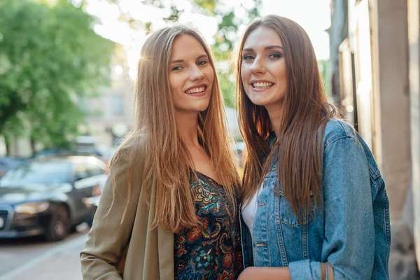 Dos chicas jóvenes de pie en la calle y mirando en el vino —  Fotos de Stock