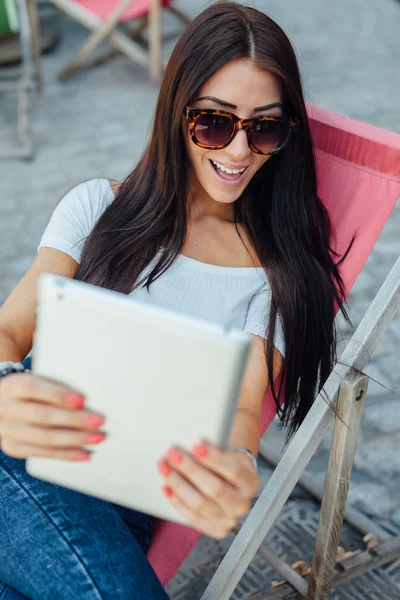 Szczęśliwa dziewczyna siedzi na solarium i biorąc selfie z jej tabl — Zdjęcie stockowe