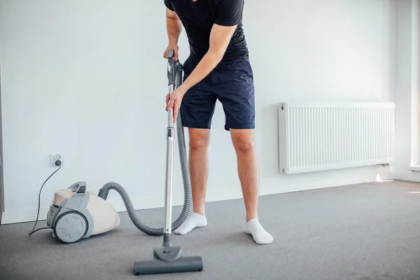 O homem está a aspirar. Home floor . — Fotografia de Stock