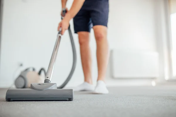 O homem está a aspirar. Home floor . — Fotografia de Stock